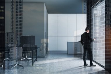 Masa ile gri mutfakta telefon ile Adam