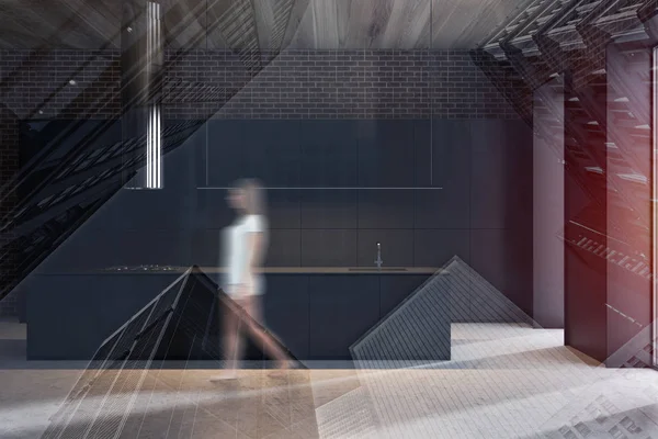 Woman walking in black kitchen with island