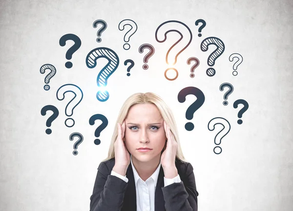 Stressed woman in suit, question marks — Stock Photo, Image