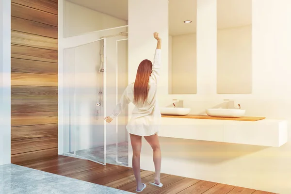 Woman in bathroom corner with sink and shower — 스톡 사진