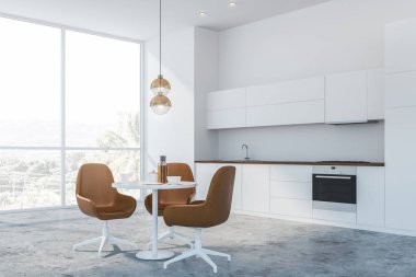 Masa ve kahverengi sandalyeli beyaz mutfak köşesi