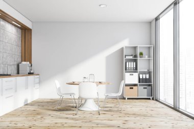 Masası ve kitaplığı olan beyaz mutfak.