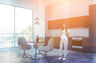 Beyaz mutfak köşesinde kadın, sayaçları ve masa