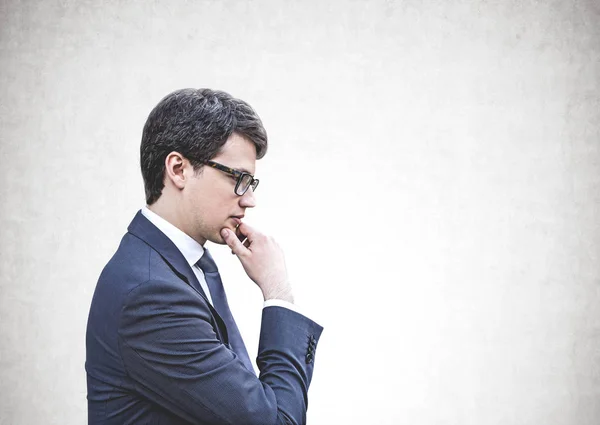 Gondolkodó fiatal üzletember a szemüveg, kigúnyolják — Stock Fotó