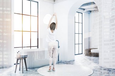 Beyaz banyo ve oturma odası köşesinde kadın