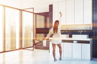 Mavi banyo köşesinde kadın, lavabo ve küvet