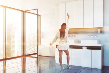 Beyaz banyo köşesinde kadın, lavabo ve küvet