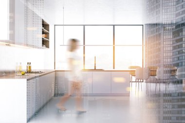 Beyaz mutfakta yürüyen kadın