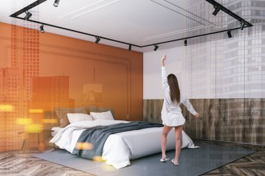 Turuncu ve beyaz yatak odası köşesinde kadın