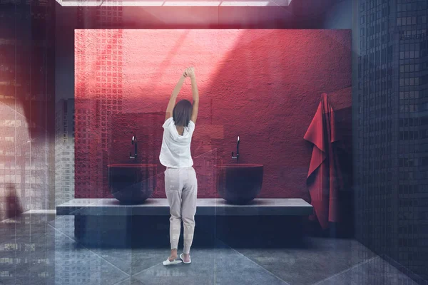 Mujer en baño rojo con doble lavabo — Foto de Stock