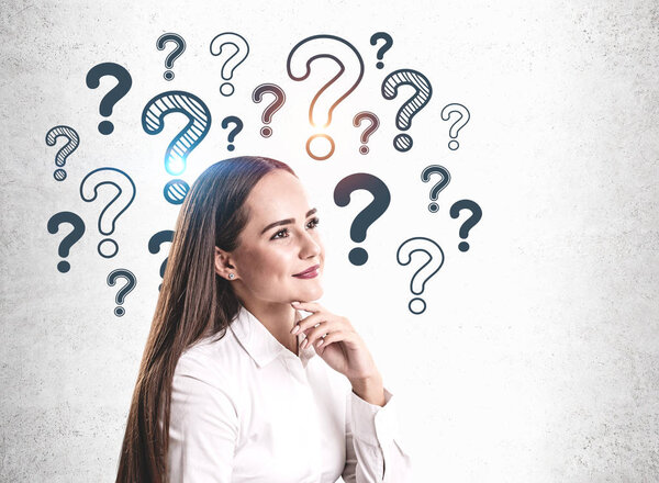 Задуманная молодая женщина и вопросительные знаки
