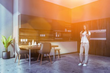 Fırınlar ve masa ile gri mutfakta Kadın