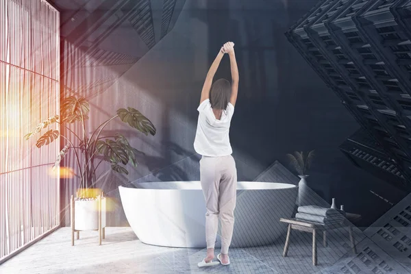 Mujer en baño gris con bañera y persianas — Foto de Stock