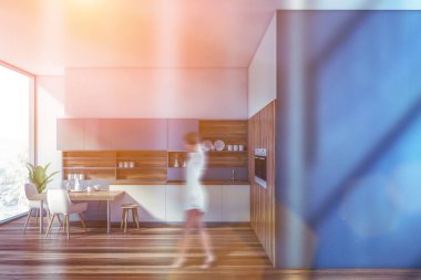 Mavi mutfakta yürüyen kadın