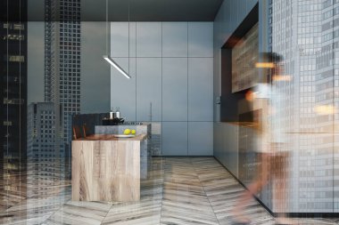 Bar ile gri mutfakta yürüyen kadın