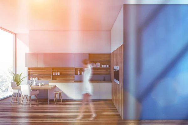 Kobieta chodzenie w niebieski kuchnia — Zdjęcie stockowe