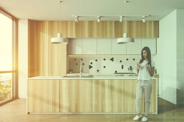 Mujer en cocina blanca y de madera con isla — Foto de Stock