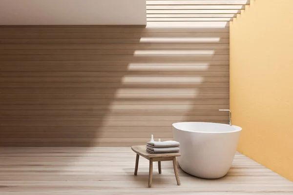 Просторная желтая и деревянная ванная комната с ванной — стоковое фото