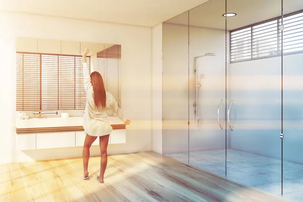 Mujer en baño blanco con ducha y lavabo — Foto de Stock