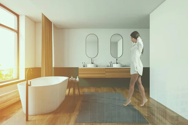 Женщина ходит в белой и зеленой ванной комнате — стоковое фото