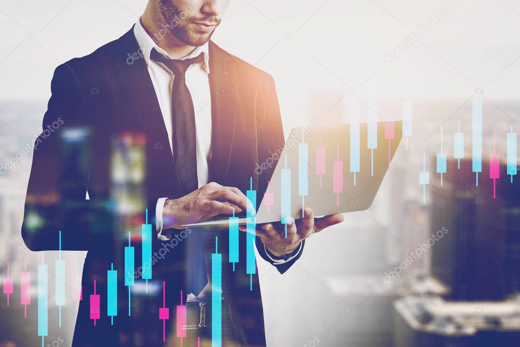 Man with laptop in city, financial graph