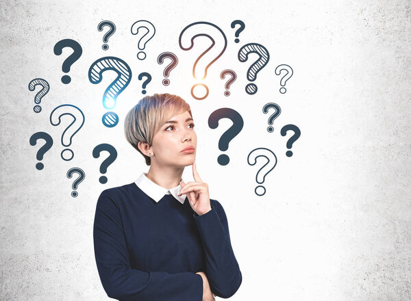 Задуманная молодая женщина и вопросительные знаки
