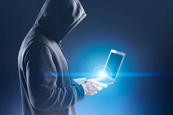 Вид збоку невпізнаваного хакера з ноутбуком — стокове фото
