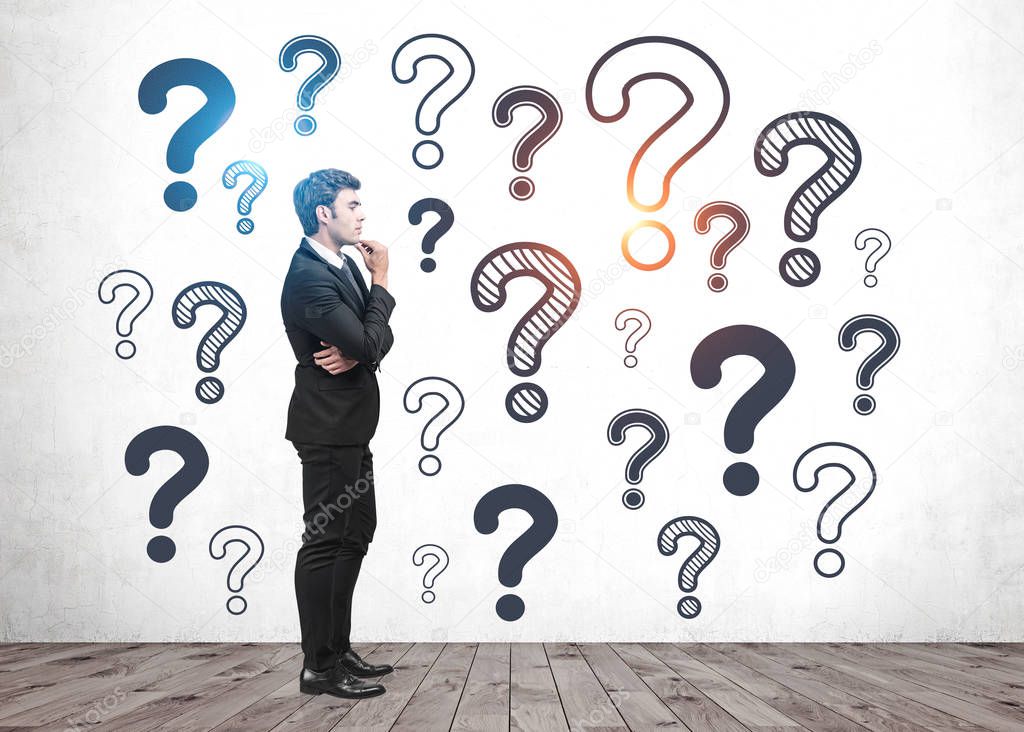 Thinking businessman in room with question marks