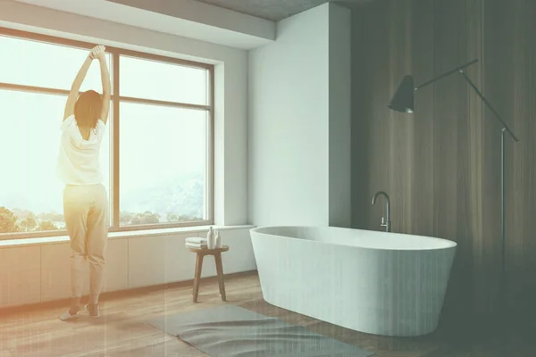 Woman in white and wooden bathroom with tub — Stock Photo, Image