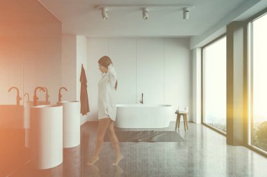 Beyaz panoramik banyodaki genç kadın.