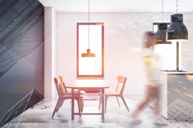 Beyaz ve siyah mutfakta yürüyen bir kadın.