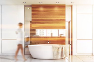 Lüks beyaz ve ahşap banyoda yürüyen bir kadın.