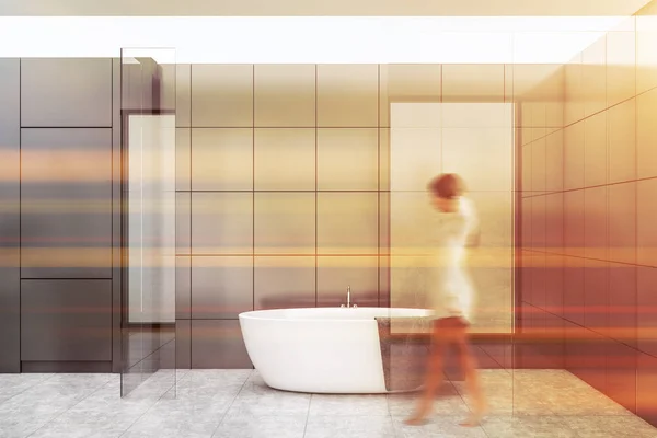 Žena chodí v šedé dlaždice koupelna — Stock fotografie