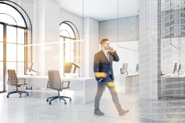 Telefondaki adam beyaz açık uzay ofisinde.