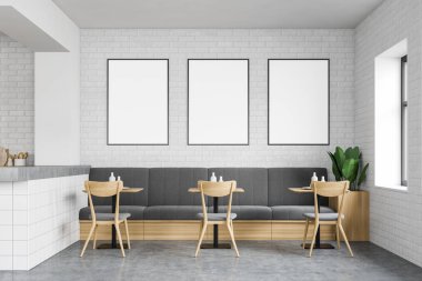 Kanepesi ve posterleri olan beyaz tuğlalı bir restoran.