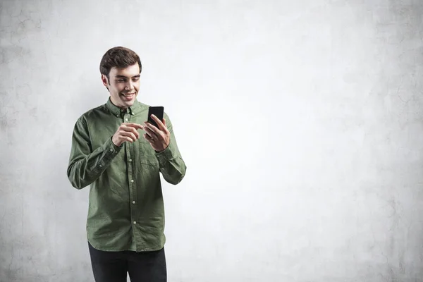Sonriendo joven hombre casual usando smartphone, burlarse de — Foto de Stock