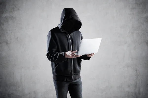 Неузнаваемый молодой хакер с ноутбуком — стоковое фото