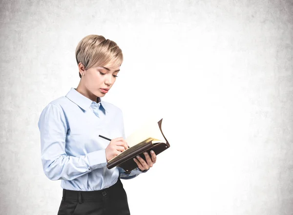 Mujer de negocios seria escribiendo en cuaderno, maqueta — Foto de Stock