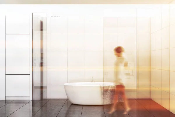 Mulher andando no banheiro de azulejo branco — Fotografia de Stock