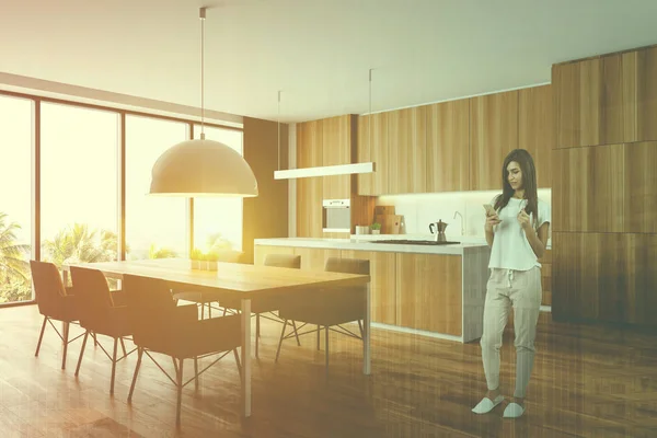 Woman in wooden kitchen with table Stock Image