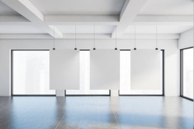 Beyaz duvarlı, döşemeli ve bulanık şehir manzaralı büyük pencereli boş sanat galerisinde asılı üç adet dikey maket poster. Reklam kavramı. 3d oluşturma