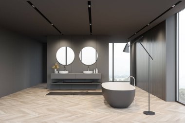 Geniş bir banyo, gri ve koyu ahşap duvarlar, ahşap zemin, pencerenin yanında duran rahat bir küvet, bulanık dağ manzaralı ve çift lavabolu yuvarlak aynalar. 3d oluşturma