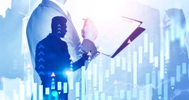 Bulanık Moskova 'da birlikte çalışan iki genç tüccarın siluetleri ve artan dijital grafiğin iki katına çıkarılması. Borsa ve başarılı finans ekibi kavramı. Tonu ayarlanmış resim