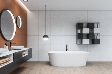Modern banyo, beyaz ve kahverengi fayanslı duvarlar, fayanslı zemin, gri tezgahta duran çift lavabo, yuvarlak aynalar ve beyaz küvet. 3d oluşturma