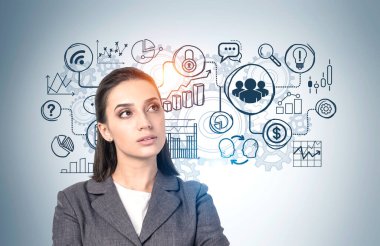 Üzerinde yaratıcı iş planı çizimi olan gri duvarın yanında duran zarif takım elbiseli düşünceli genç iş kadını. İş stratejisi geliştirme kavramı