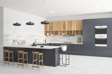 Corner of modern kitchen with grey and white walls, grey countertops, wooden cupboards, bar with stools, two ovens and window with blurry cityscape. 3d rendering clipart