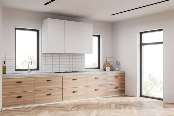 白とタイル張りの壁 木製の床 シンクや調理器や窓に組み込まれているカウンターとの現代的なキッチンの隅にぼやけた熱帯の景色 3Dレンダリング — ストック写真