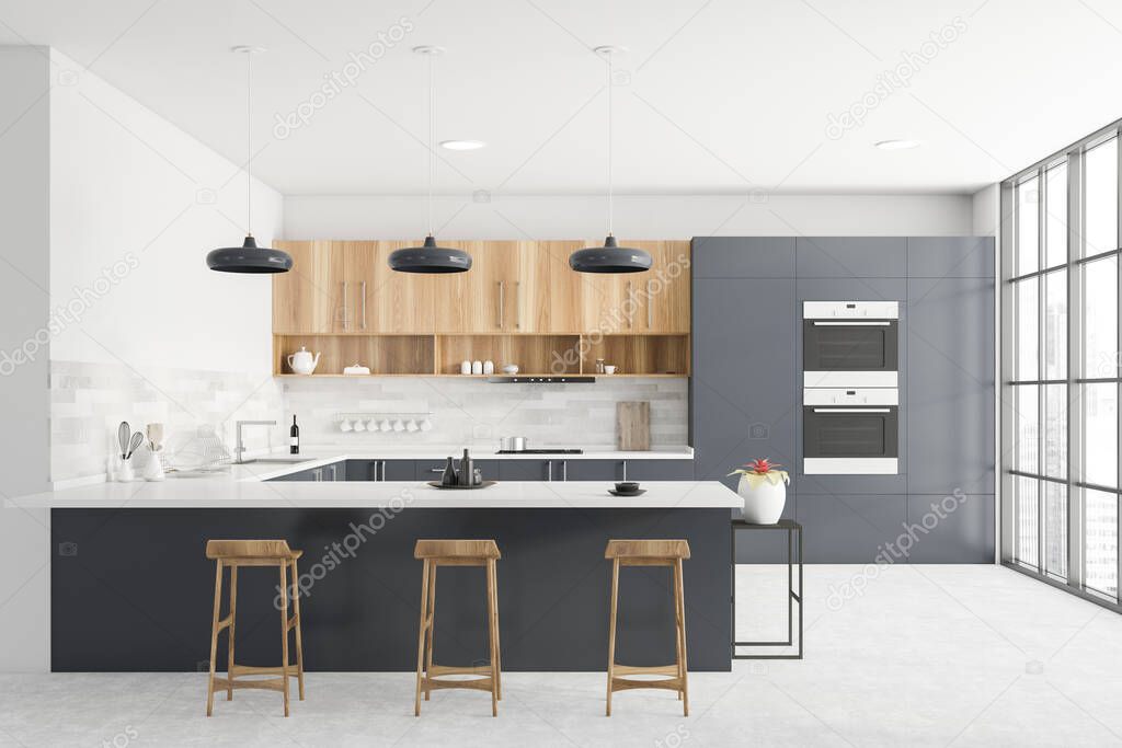 Interior of modern kitchen with grey and white walls, grey countertops, wooden cupboards, bar with stools, two ovens and window with blurry cityscape. 3d rendering