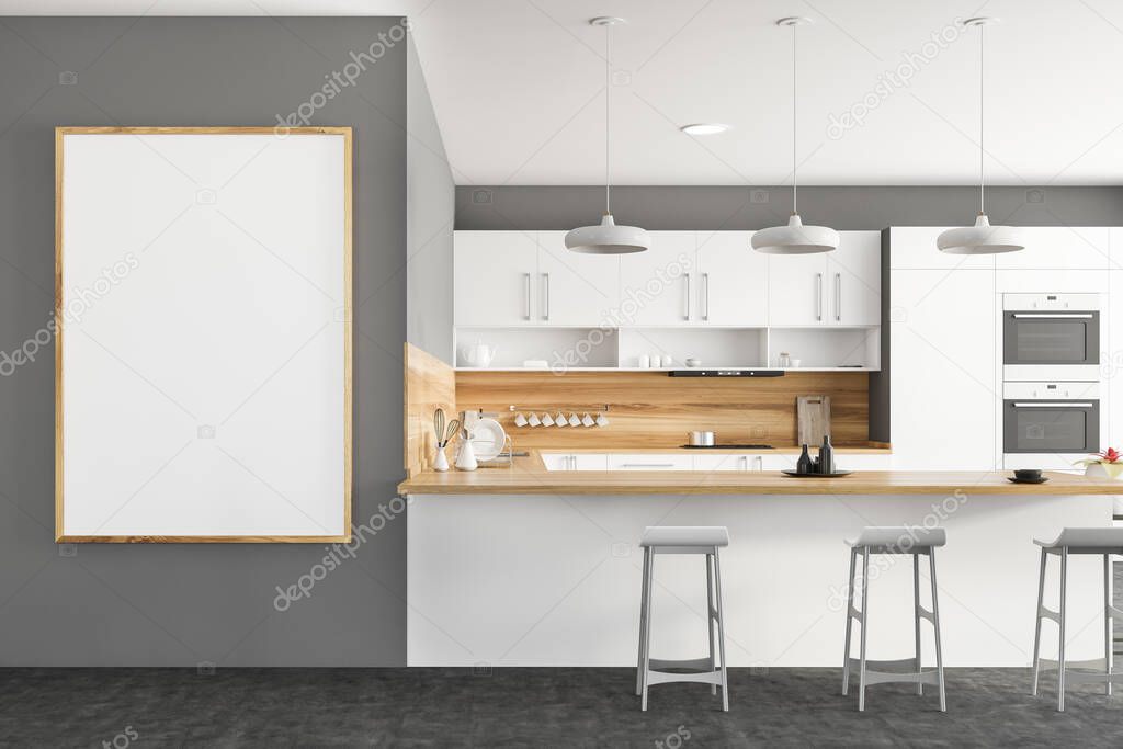 Interior of stylish kitchen with grey and wooden walls, white countertops and cupboards, bar with stools, two ovens and vertical mock up poster frame. 3d rendering