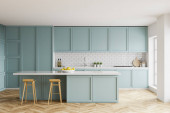 Interiér stylové kuchyně s bílými a cihlovými stěnami, dřevěnou podlahou, modrými pulty a skříněmi a barem se stoličkami. 3D vykreslování